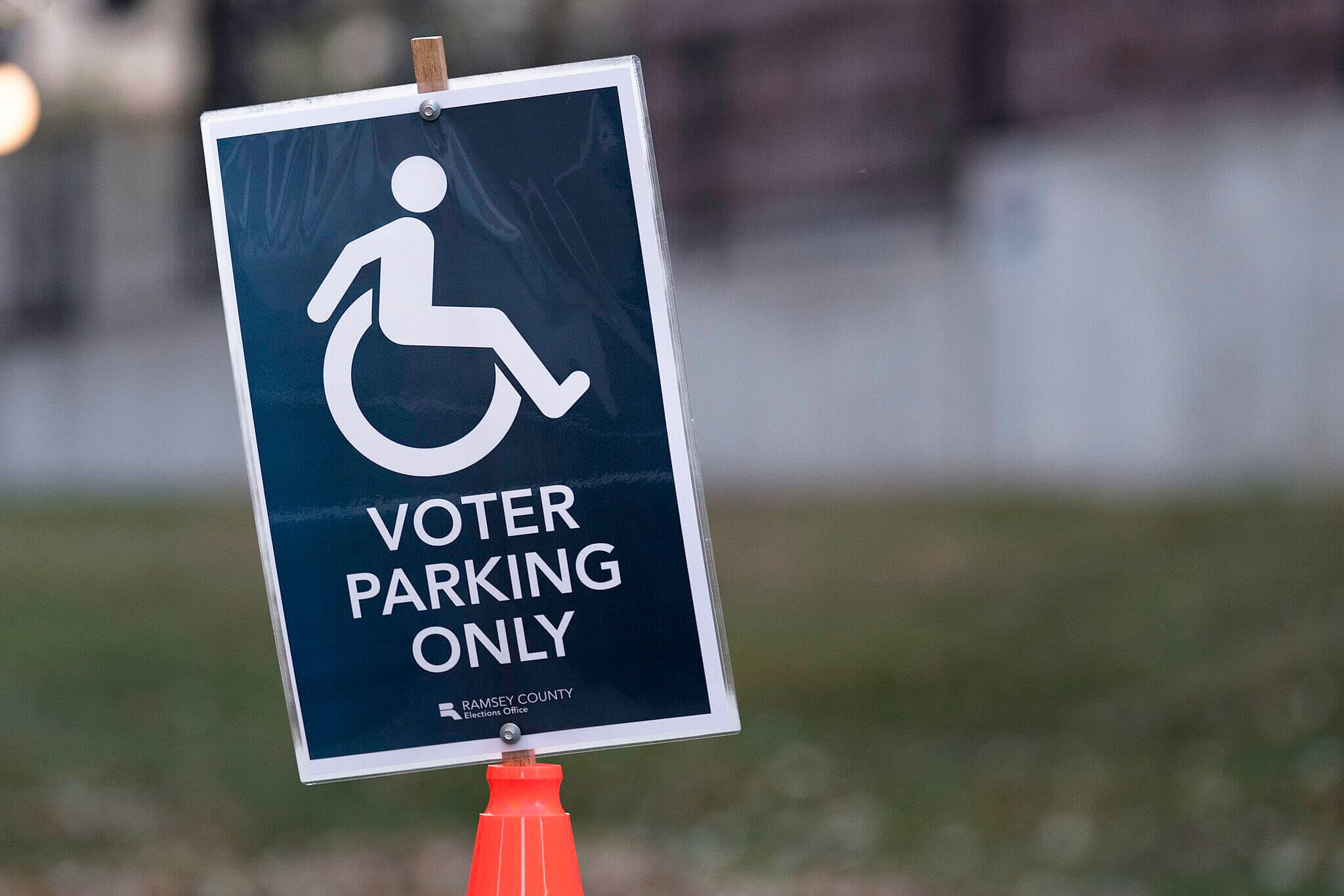 A blue sign with white words reading “Voter parking only” and a white symbol of a wheelchair user. The sign is from an election in Minnesota, United States.