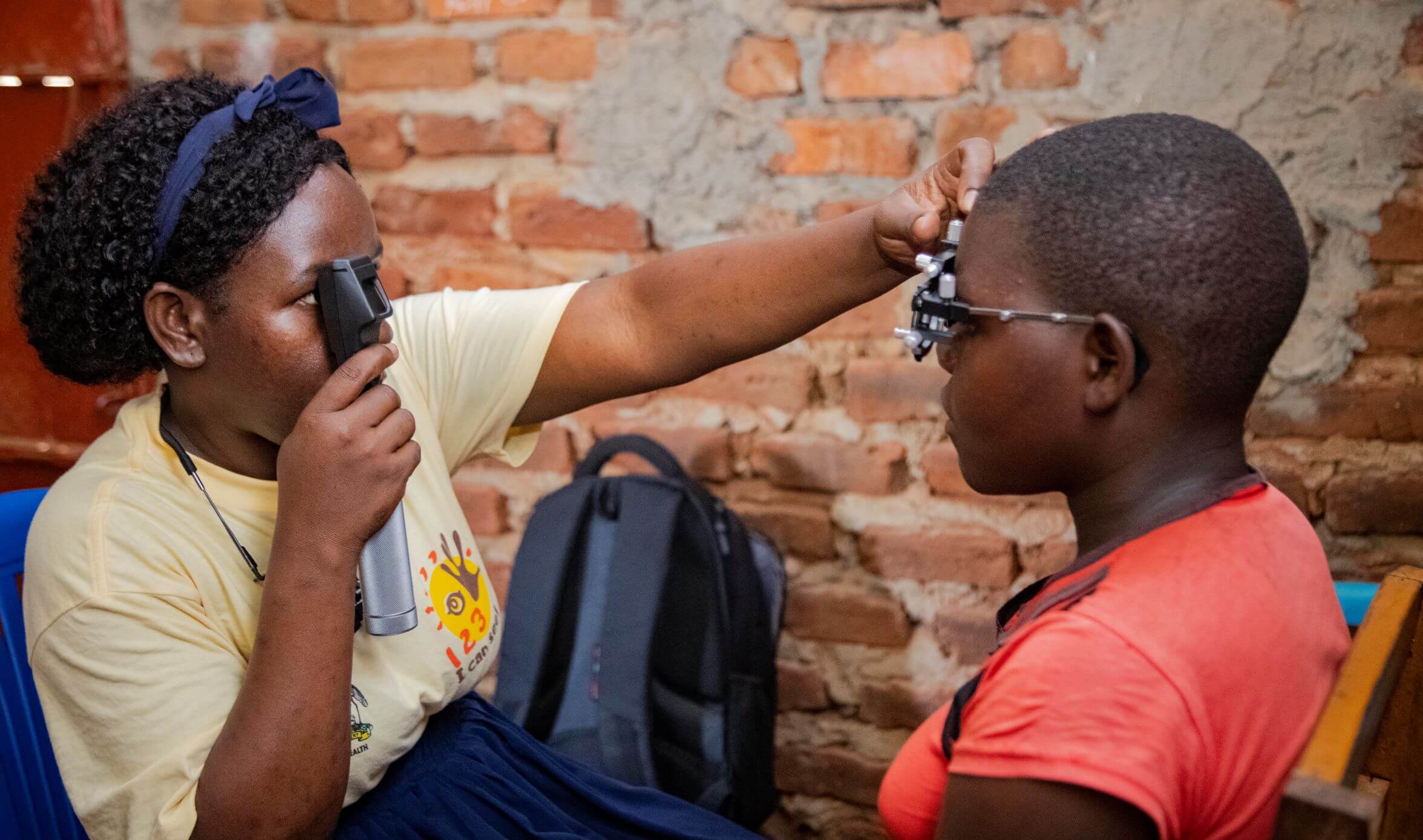 Atim Mercy, Ophthalmic Clinical Officer of Pallisa District carries out a low vision assessment on a student.