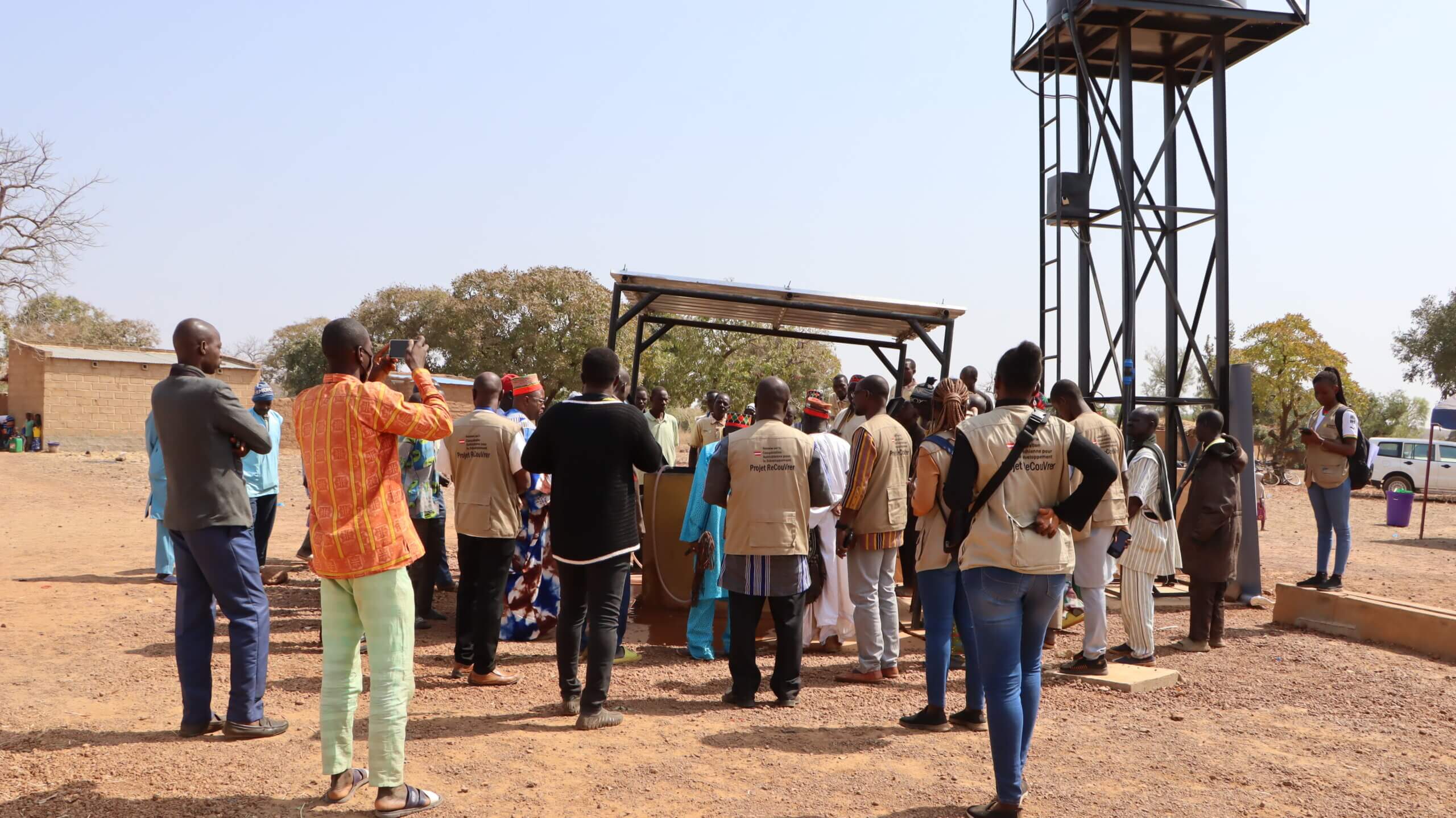 Residents and Decouvrer II staff celebrate the completion of autonomous water stations and the repair of three boreholes in Tanlouka village, Burkina Faso, ensuring access to clean water.